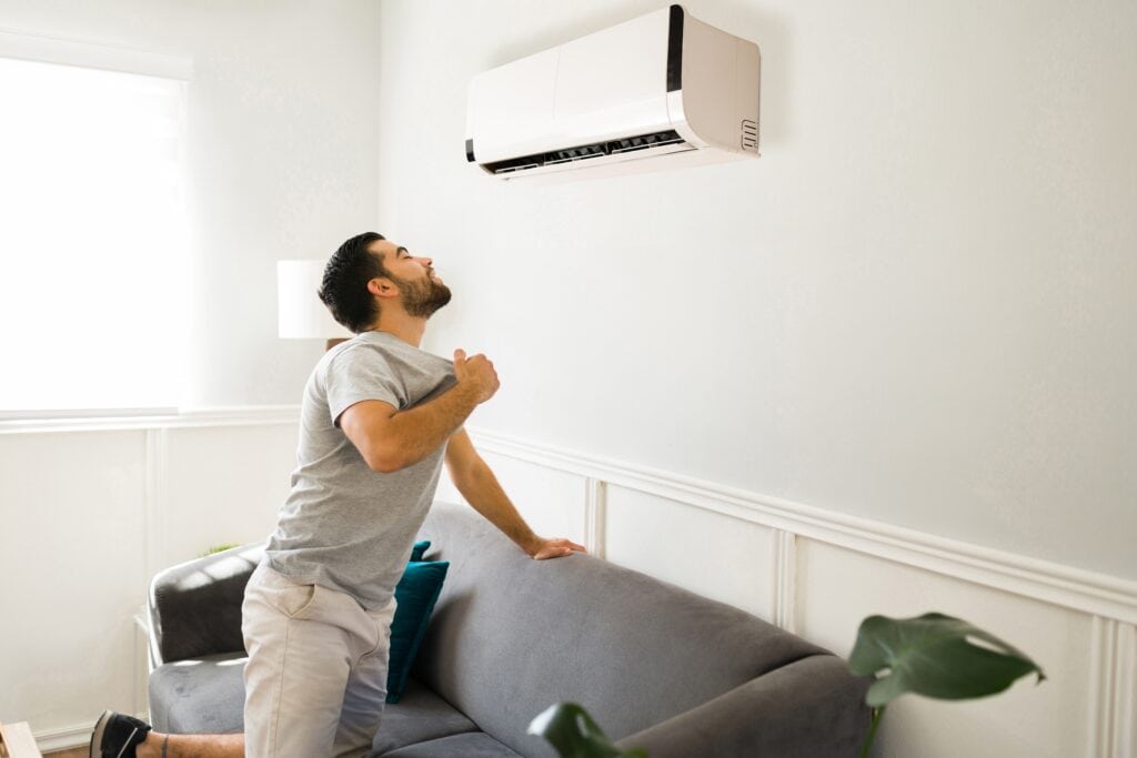 sweating man faces ac unit | Don't Sweat It! Call Manuel & Sons For A/C Trouble